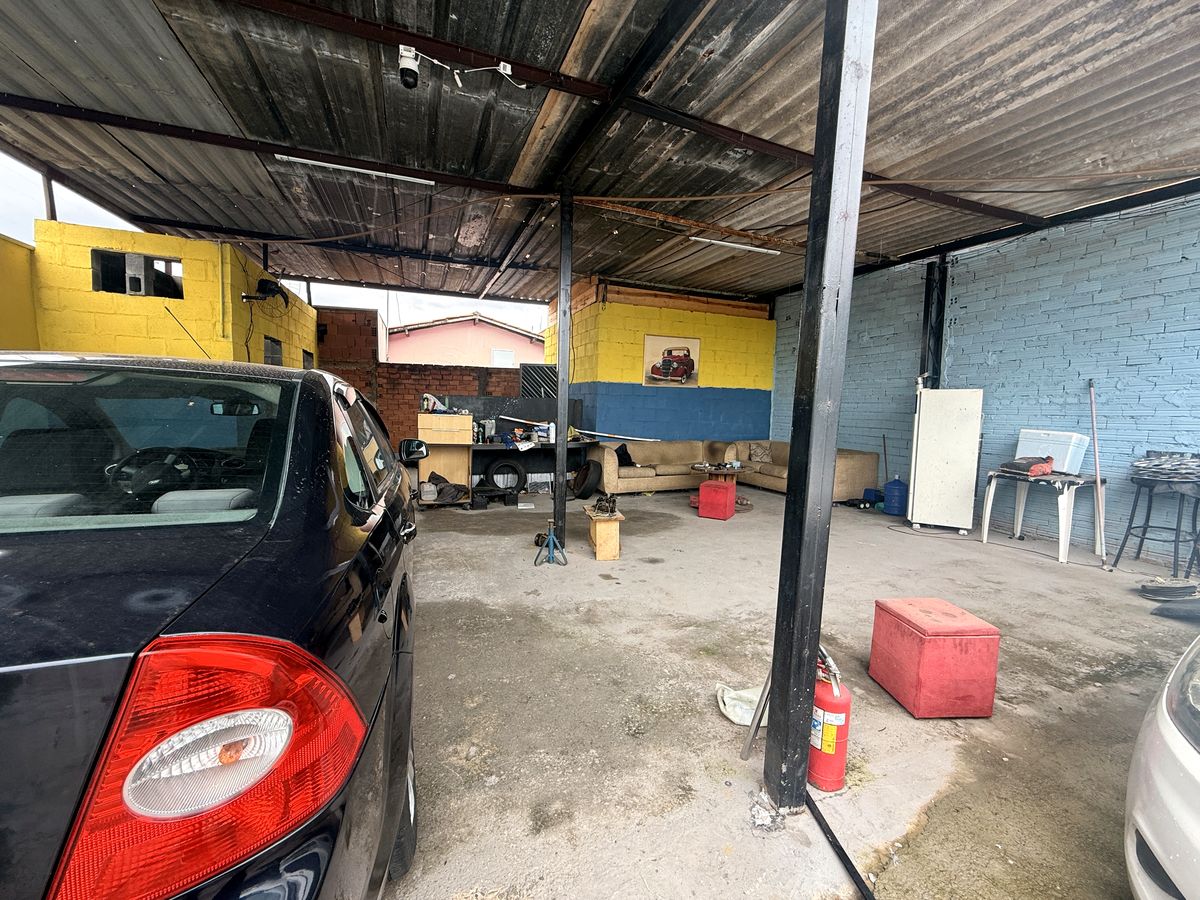 Área coberta interna da Auto Elétrica Diego, com paredes amarelas e azuis